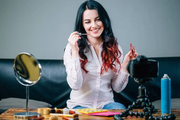 Blogger femenina con cosméticos de maquillaje grabando video en casa — Foto de Stock