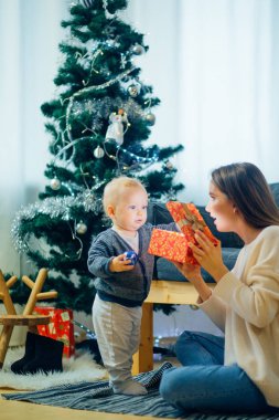 Anne ve oğlu sihirli bir Noel hediyesi Noel ağacı oturma odasında açmalarına