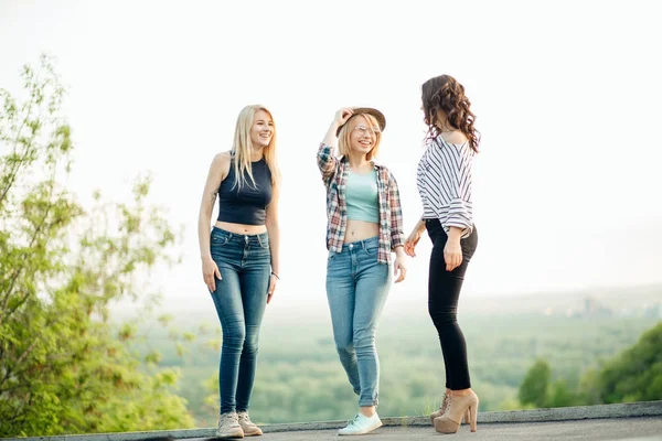 Three attractive young women talking a walking together — Stock Photo, Image