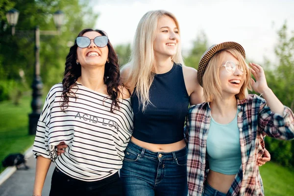 Drie aantrekkelijke jonge vrouwen praten een lopen samen — Stockfoto