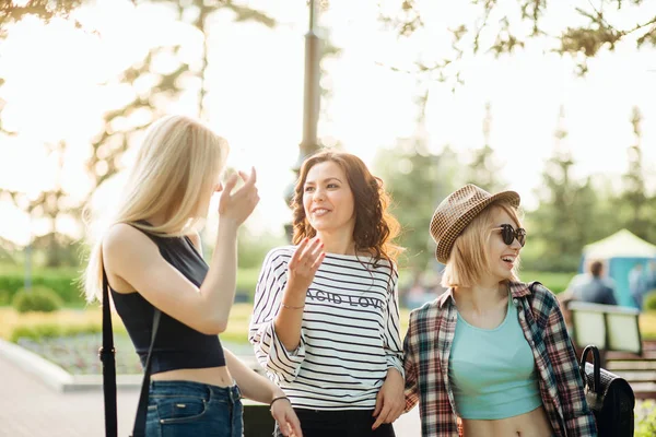 Drie aantrekkelijke jonge vrouwen praten een lopen samen — Stockfoto