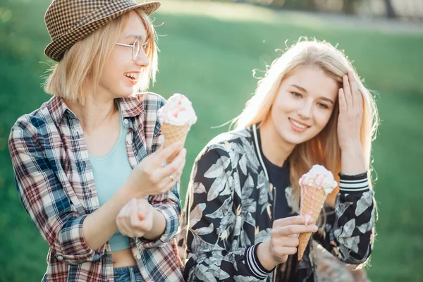 Due donne che tengono in mano il cono di cialda gelato fondente in luce estiva — Foto Stock