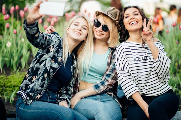 Estate ritratto all'aperto di tre amici ragazze divertenti scattare foto con smartphone — Foto Stock