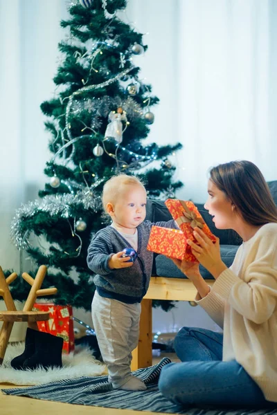 母と息子のリビング ルームでクリスマス ツリーが魔法のクリスマスのギフトを開く — ストック写真