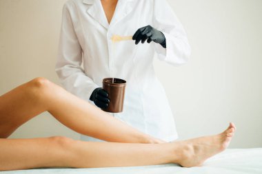 İstemci bekle, arka plan üzerinde sıcak balmumu ile kadın holding kase