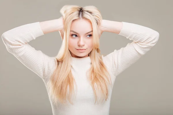 灰色の背景に対して髪に手を持つ若い女性 — ストック写真