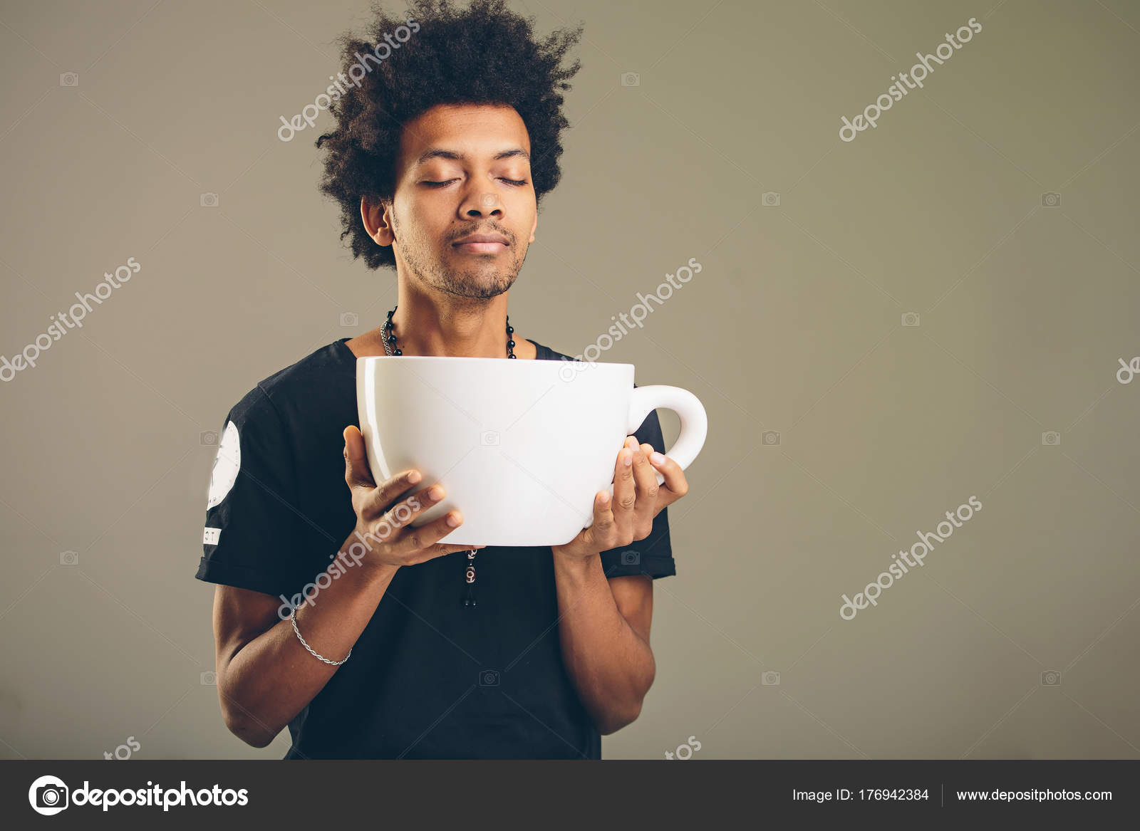 Man holding funny huge and oversized cup of black coffee Stock Photo by 176942384