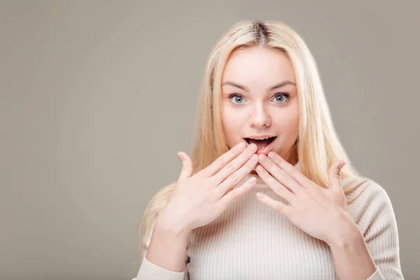 Femme surprise montrant le produit. Belle fille avec les cheveux bouclés pointant vers le côté — Photo