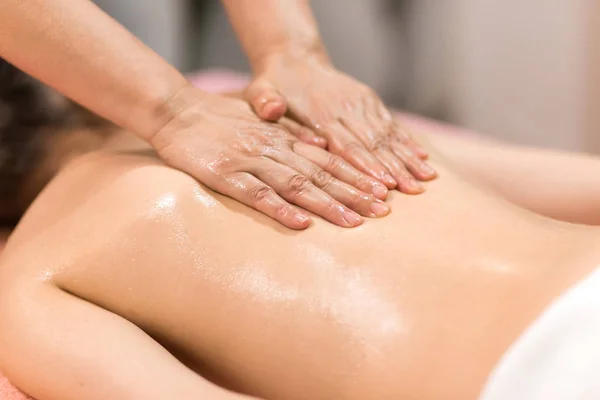 Bir Spa merkezinde masaj yağı ile masaj sahip kadın — Stok fotoğraf