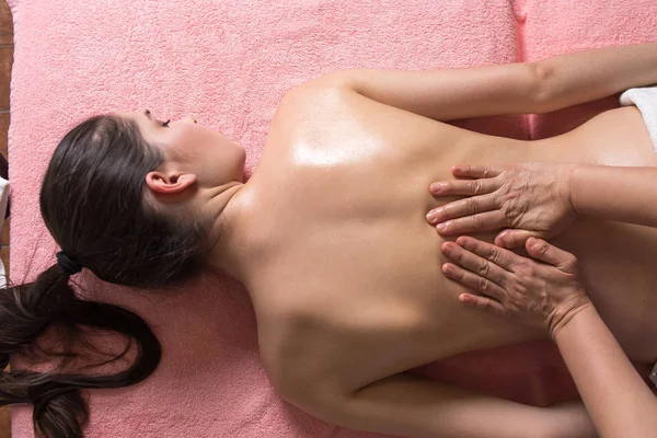 Masör spa salonundaki kadına masaj yapıyor. en üstteki görünüm — Stok fotoğraf