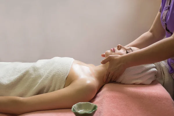 Vrouw liggen met gesloten ogen en het hebben van gezicht of hoofd massage in spa — Stockfoto