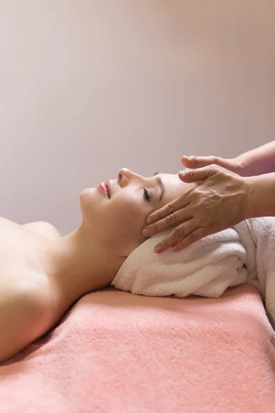 Masseur fazendo massagem a cabeça de uma mulher caucasiana no salão de spa — Fotografia de Stock