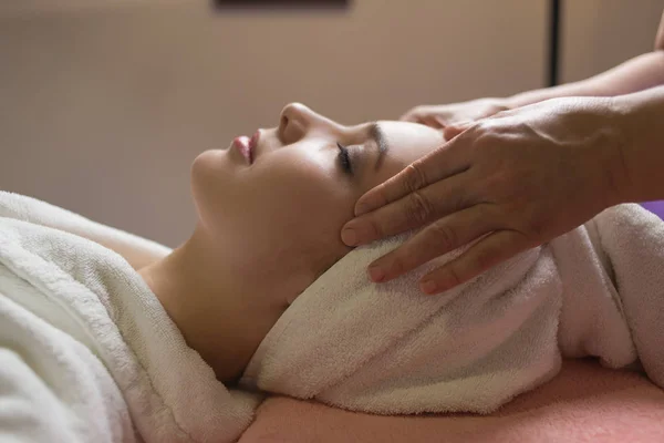 Massaggiatore facendo massaggio la testa di una donna caucasica nel salone termale — Foto Stock