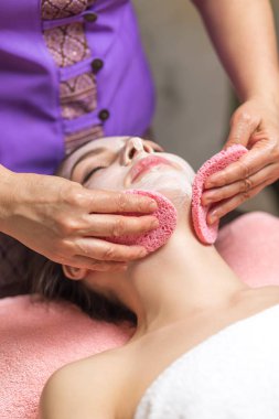 Spa konsepti. Güzellik salonunda besin maskesi takan genç bir kadın.