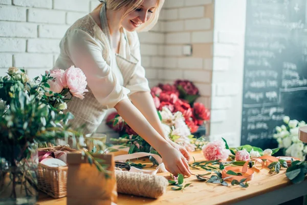 Florista lugar de trabajo: mujer que organiza un ramo con flores — Foto de Stock