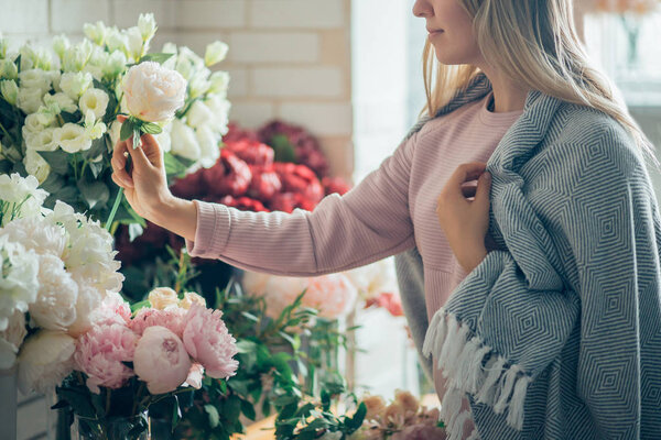 florist takes a flower to make a bouquet