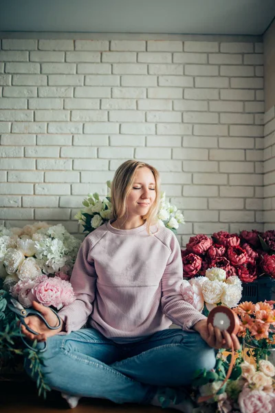 Beautiful girl with bouquet flowers peonies in hands sitting on table