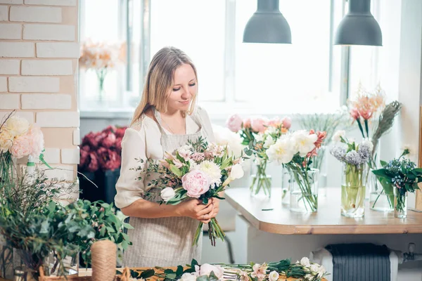 Linda florista joven concentrada en gafas que trabajan en la tienda de flores —  Fotos de Stock