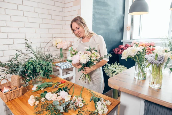 Ganska ung blond kvinna att göra mode moderna bukett av olika blommor — Stockfoto