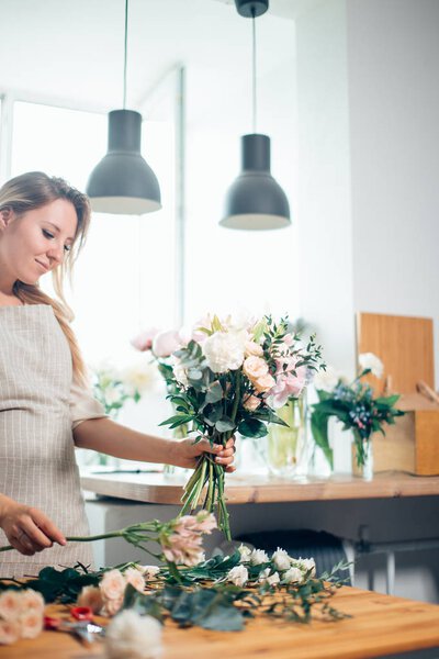 florist unfocused in flower shop. Floral design studio, making decorations