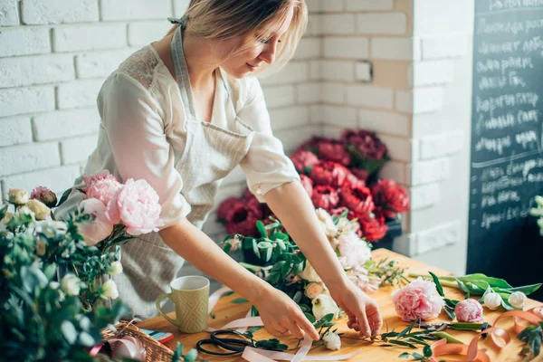 Florist på jobbet: ganska ung blond kvinna att göra olika blombukett — Stockfoto