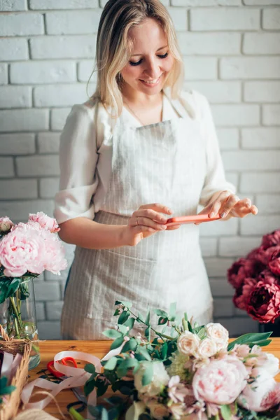 Florist fotografera buketten på telefonen. Mibile fotografering — Stockfoto