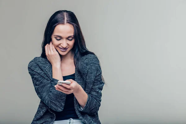 Счастливая девушка читает сообщение на смартфоне — стоковое фото