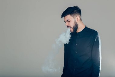 Elektronik sigara içen sakallı bir adam. Vaper hipster duman buharlaştırıcı..
