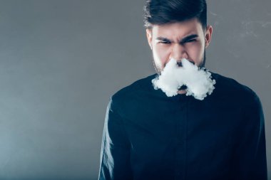 Güneş gözlüklü sakallı adamlar buharlaşıyor ve bir duman bulutu salıyor..