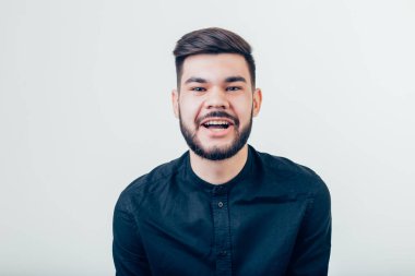 Yakışıklı genç adam kameraya bakıyor. Gülen genç adamın portresi