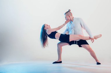 Modern tarz güzel dansçılar spor yapıyor. Genç adam kız arkadaşını tutuyor.