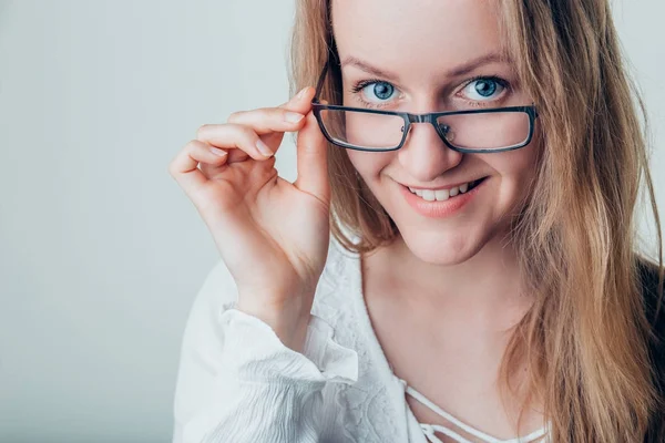 Sourire jeune femme d'affaires portant des lunettes de vue regardant la caméra — Photo
