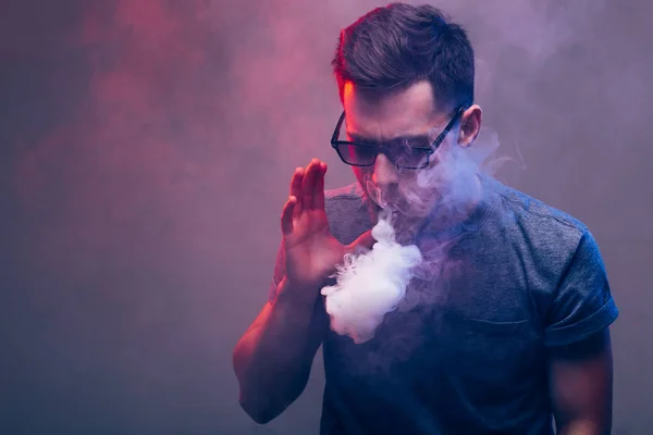 Homem com barba a vaporizar um cigarro electrónico. Vaper hipster vaporizador de fumaça . — Fotografia de Stock