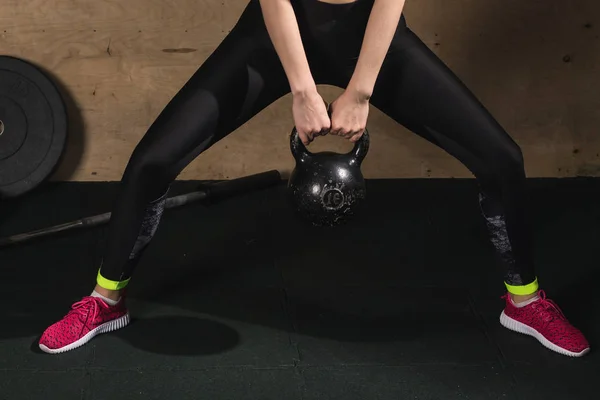 Mujer en forma levantando pesadas pesas tetera campana en el gimnasio — Foto de Stock