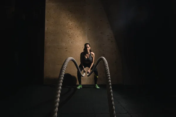 woman working out with battle ropes