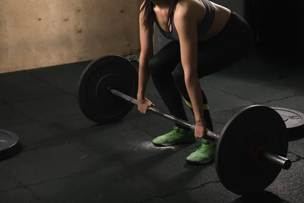 Mujer muscular en un gimnasio haciendo ejercicios de peso pesado con barra de pesas — Foto de Stock