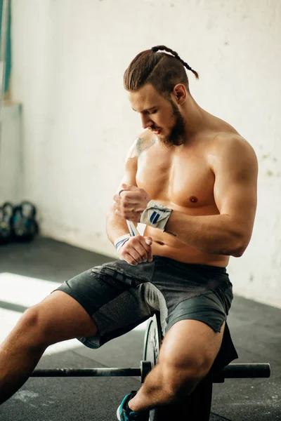 Uomo in forma prepararsi per l'allenamento, avvolgendo le mani con nastro adesivo — Foto Stock