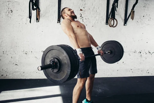 Homme soulevant des poids. musclé homme séance d'entraînement dans la salle de gym faire des exercices avec haltère — Photo