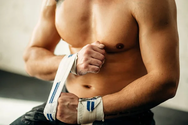 Levantador de peso muscular embrulhando as mãos e se preparando para o treino em um ginásio . — Fotografia de Stock