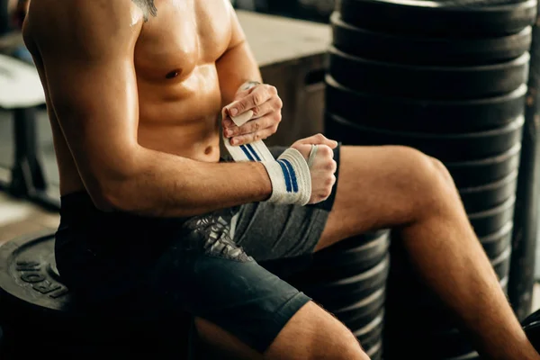 Uomo si prepara per l'allenamento, avvolgendo le mani con nastro adesivo — Foto Stock