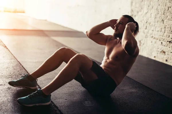 Kaslı adam yapıyor egzersiz egzersiz kadar oturmak — Stok fotoğraf