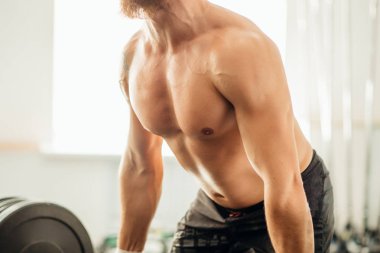 adam ağırlık kaldırıyordu. kaslı adam egzersiz halter ile egzersizleri yapıyor spor salonunda