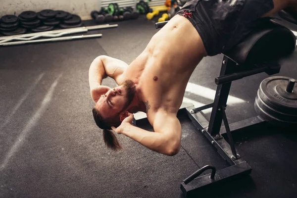 Muskularny mężczyzna wykonując robi siedzieć ćwiczenia — Zdjęcie stockowe