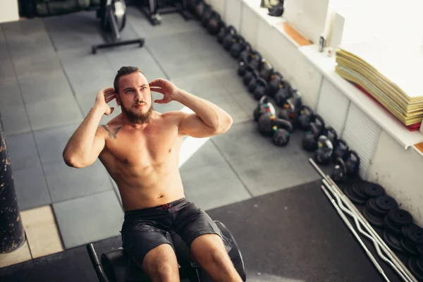 Homem muscular exercitando-se fazendo sentar-se exercício — Fotografia de Stock