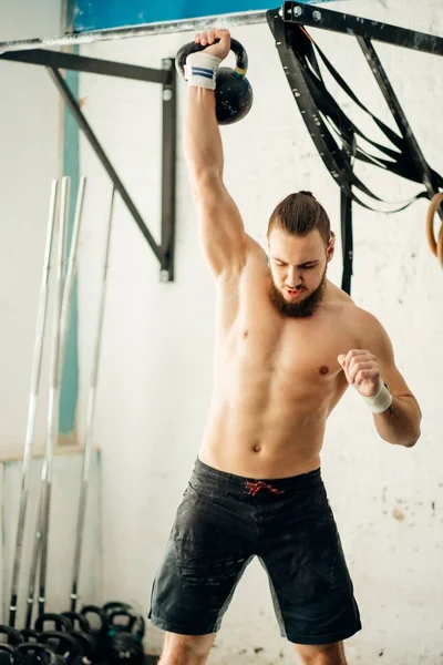 su ısıtıcısı bell.caucasion erkek atlet kettlebell ile çalışma dışarı tutan adam