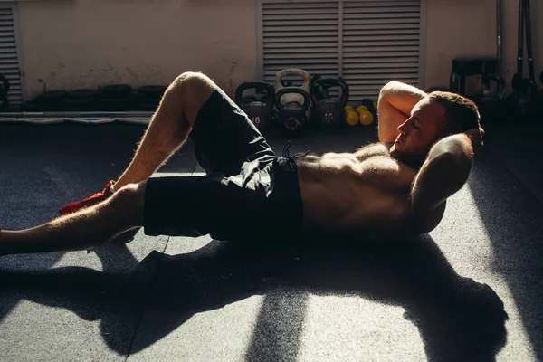 Homem muscular exercitando-se fazendo sentar-se exercício — Fotografia de Stock
