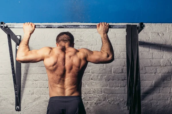 Montare le dita dei piedi per bar uomo pull-up bar esercizio di allenamento in palestra — Foto Stock