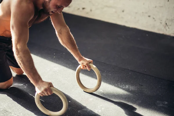 Erős ember csinál fekvőtámaszokat gyűrűk. — Stock Fotó