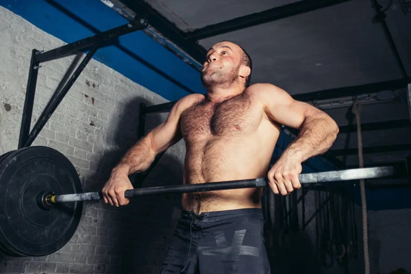 kaslı adam egzersiz halter ile egzersizleri yapıyor spor salonunda