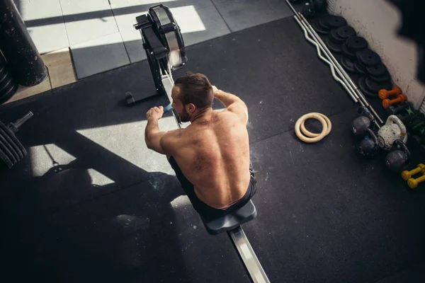 Exercícios masculinos esportivos cansados na máquina de musculação de poder em um clube de ginástica — Fotografia de Stock